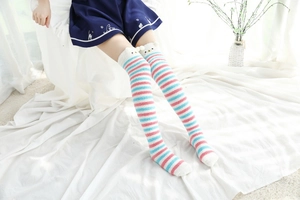 Vue détaillée des chaussettes hautes rayées en polaire avec décorations d'oreilles d'ours