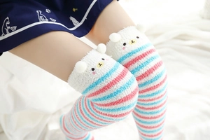 Détail de chaussettes hautes en polaire corail avec rayures roses et oreilles d'ours 3D