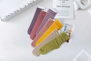 Detailed view of colorful velvet slouch socks with vertical ribbed texture in Morandi tones