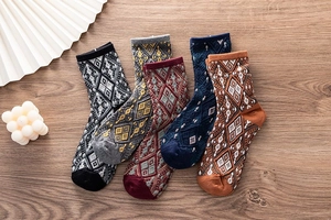 Détail de cinq paires de chaussettes en coton rétro à motifs sur une surface en bois
