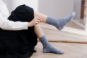 Detailed view of grey-blue crew socks with elegant vintage floral jacquard pattern