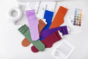 Flat lay of colorful ribbed velvet slouch socks in purple blue orange and green colors