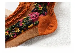 Detail of knitted cotton socks with floral embroidery and reinforced heel design