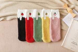 Close-up of five pairs of thick coral fleece socks with cute fruit embroidery motifs