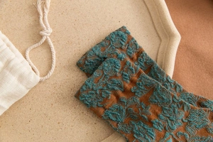 Detail of retro floral embossed knit socks with a cotton drawstring gift bag