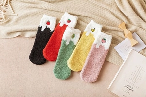 Detailed texture of thick coral fleece winter socks with cute embroidered fruit patterns