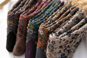 Close-up of cable knit vintage floral crew socks with glitter yarn and textured patterns