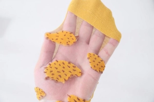 Detail of yellow semi-transparent mesh socks featuring embroidered hedgehog pattern