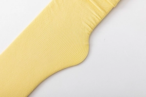 Detail shot of bright yellow velvet slouch socks showing fine vertical ribbed knit texture
