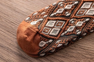 Détails de chaussettes en maille vintage aux motifs géométriques orange et bleu marine