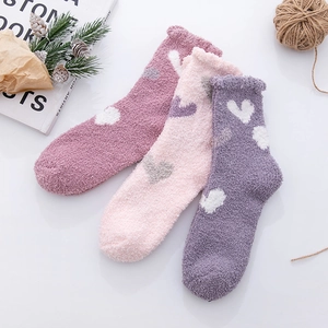 Detailed view of thick coral fleece heart pattern socks in three pastel winter colors