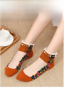 Detail of vintage style glass silk socks with floral patterns and pearl lace trim