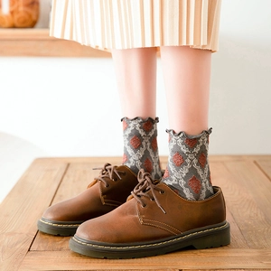 Retro grey cotton mid-calf socks with argyle pattern and ruffled edges styled with shoes