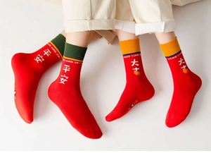 Detail von roten Socken mit chinesischen Schriftzeichen Ping'an und Daji für viel Glück