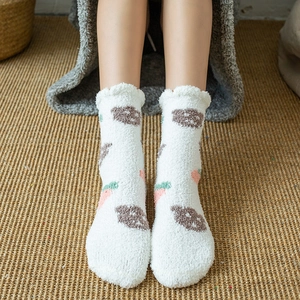 Close-up of thick coral fleece socks with cute bear patterns and ruffle trim details