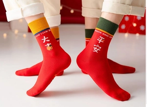 Detail von roten Baumwollsocken mit Stickerei und festlichen Rippbündchen für Neujahr
