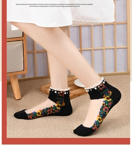 Detail of cotton socks featuring sunflower embroidery, lace trim, and pearl accents