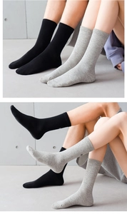 Détail de chaussettes mi-hautes en coton côtelé noir et gris avec micro-broderie fine