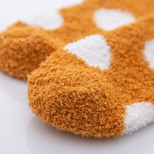 Macro shot of thick ginger and white coral fleece socks showing soft plush texture