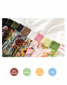 Detail of sheer mesh socks featuring vibrant sunflower and strawberry floral embroidery