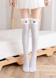 Detail of plush grey over-knee socks featuring cute white 3D bear ears and embroidery
