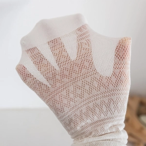 Close-up of white mesh socks showing breathable diamond knit pattern and elastic texture