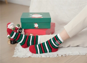 Close-up of festive red and green striped coral fleece socks with snowflake patterns