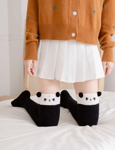 Detail of panda themed over-knee socks with 3D ears and soft coral fleece texture