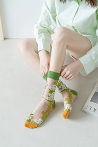 Transparente Blumen-Netzsocken mit orangen Blütenmustern und grünen Rippbündchen
