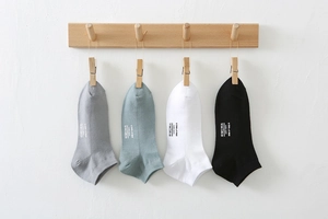 Detailed view of four pairs of breathable cotton ankle socks in various solid colors