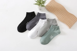 Detail of five pairs multi-color low-cut cotton socks with printed letters and mesh texture