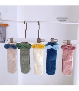 Detail of five pairs of warm coral fleece mid-calf socks with cute plush bow decoration