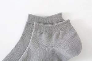 Detail view of light grey cotton ankle socks showing fine rib knit texture and elastic cuff