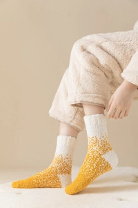 Nahaufnahme gelber Korallenfleece-Socken mit weicher Plüschtextur und Wärmegefühl