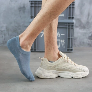 Dettaglio di calzini a rete traspiranti blu-grigio indossati con sneaker beige