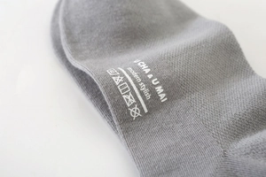 Macro detail of gray cotton socks showing knit texture and stylish printed branding