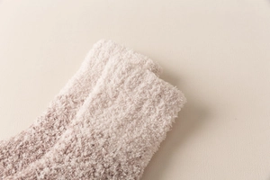 Nahaufnahme weicher Korallenvlies-Socken in Beige und Braun mit dicker Textur