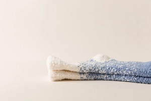 Nahaufnahme weicher Korallenvlies-Wintersocken in kuscheliger weiß-blauer Plüschoptik