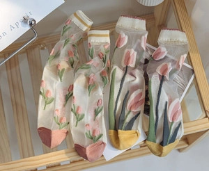 Detail of sheer glass silk socks featuring pink tulip patterns and contrast toe design