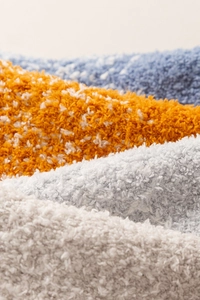 Makro-Textur weicher Korallenfleece-Socken in Hellblau, Orange und Grautönen