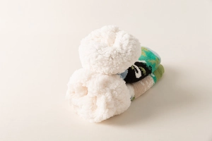 Λεπτομέρεια από παχιά επένδυση fleece sherpa και πράσινα πλεκτά σχέδια σε χειμερινές κάλτσες