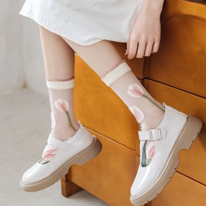 Detail of sheer glass socks with pink tulip floral print paired with white Mary Janes
