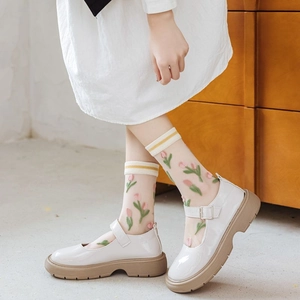 Close-up of white sheer socks featuring exquisite tulip floral embroidery and mary jane shoes