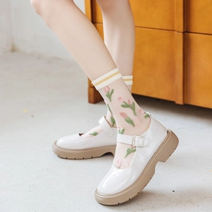 Detailed view of pink tulip embroidery on sheer white mesh socks with Mary Jane platform shoes