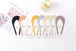 Flat lay of seamless low-cut socks in eight colors with magazines and minimalist decor