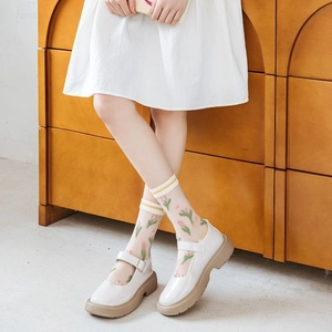 Detail of sheer tulle socks with tulip floral pattern and yellow ribbed cuffs