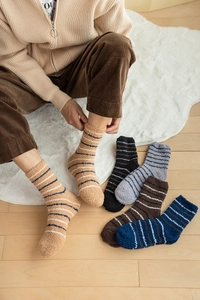 Close-up of thick striped coral fleece socks in assorted colors for winter warmth