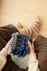 Close-up of thick striped coral fleece socks in assorted warm colors for winter