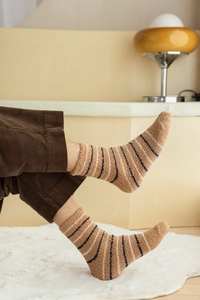 Close-up of thick striped coral fleece socks worn in a warm indoor home setting