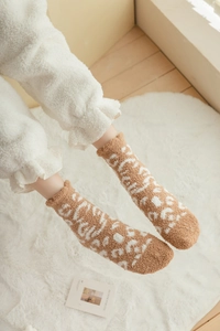 Detail of coral fleece winter socks showing plush leopard pattern and ruffled edges